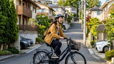坂道を楽に登る電動アシスト自転車に乗る女性